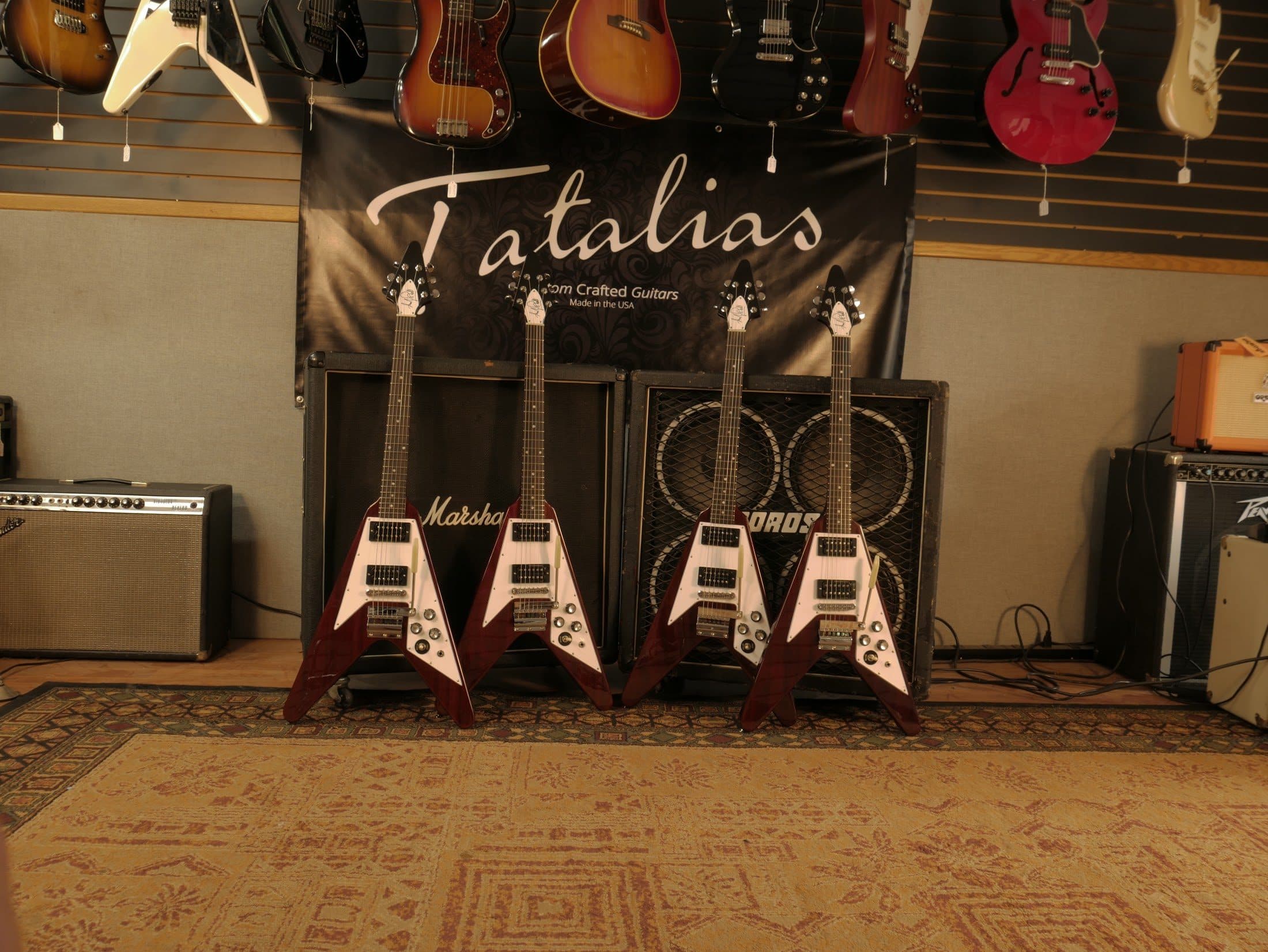 Four Andy Powell Signature Flying Vs under the Tatalias banner in the Brookfield showroom